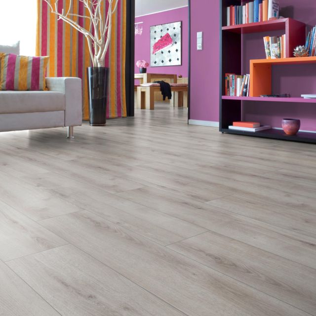 suelo laminado roble Sommer Roble gris D3904 instalado en una habitación colorida.