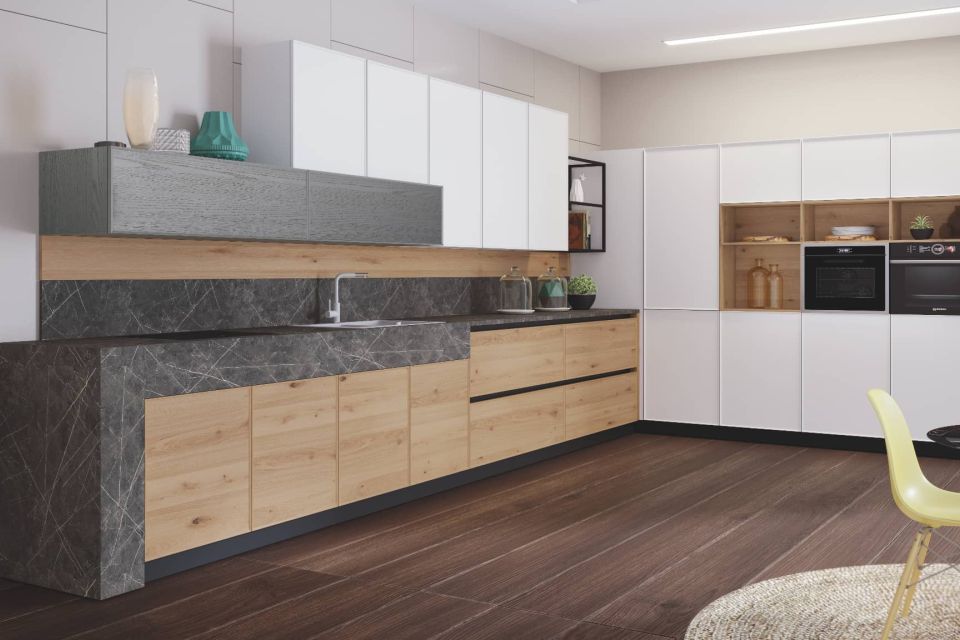 Cocina a medida con madera clara, muebles altos con puertas blancas, encimera mármol gris.