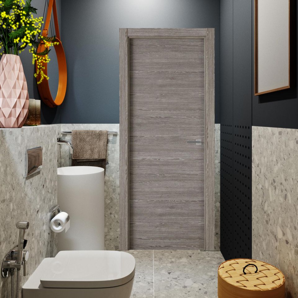 Puerta laminada X1000 Zenic Perciber instalada en baño moderno con paredes gris cemento y decoración minimalista, mostrando su acabado gris y vetas horizontales.