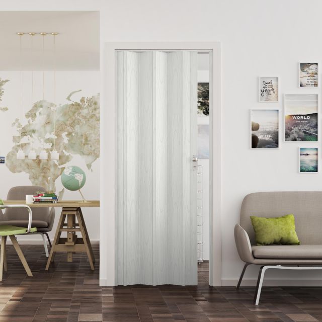 Puerta plegable de color blanco vetas instalada en una habitacion moderna